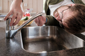 Man looks in bewilderment at the faucet from which water has stopped flowing, above the sink - PhotoDune Item for Sale