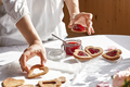 Woman making heart shaped homemade cookies with strawberry jam on the table with white tablecloth. - PhotoDune Item for Sale