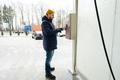 Man charges the device box with money at a self service wash in cold weather. - PhotoDune Item for Sale