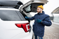Man wipes trunk of american SUV car with a microfiber cloth after washing in cold weather. - PhotoDune Item for Sale