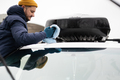 Man wipes american SUV car roof rack with a microfiber cloth after washing in cold weather. - PhotoDune Item for Sale