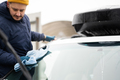 Man wipes american SUV car windshield with a microfiber cloth after washing in cold weather. - PhotoDune Item for Sale