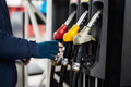 Close up hand of man hold fuel pump while refueling his car at the gas station in cold weather. - PhotoDune Item for Sale