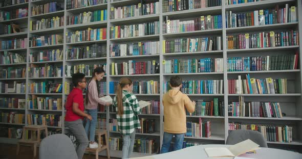 Schoolchildren Take Books From Shelves to Read in Library