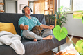 Mature middle-aged overweight man in wireless headphones meditation at home with his cat. - PhotoDune Item for Sale