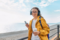 Woman listening music or podcast from smartphone application in headphones in nature - PhotoDune Item for Sale