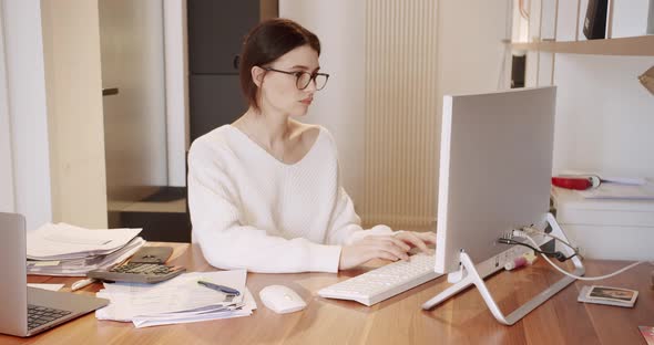 Young Business Woman in Glasses Working in Office Interior on Pc on Desk Typing