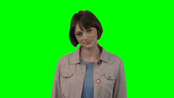 Portrait of woman standing against green background