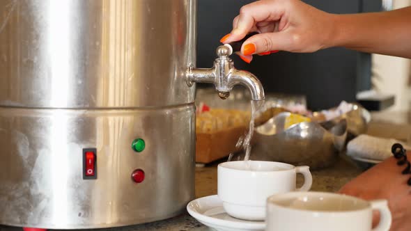 Close-up, Female Hand Turns on the Tap of Hot Water Container, Then Pours Boiling Water Into a Cup