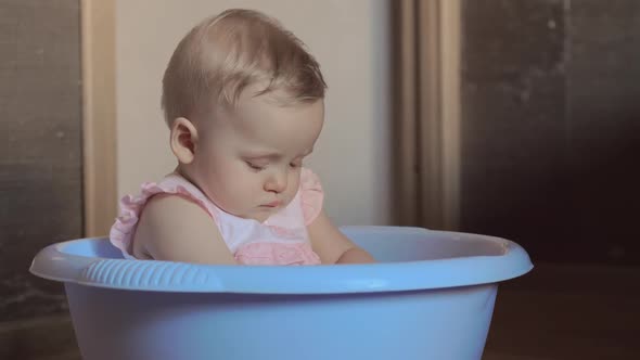 Cute Baby Girl in a Round Blue Tub