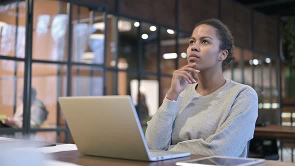 African Woman Thinking While Relaxing At Work