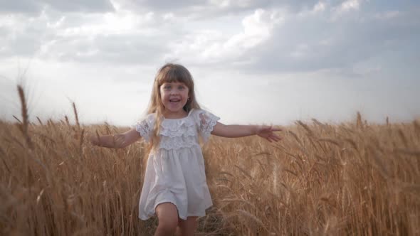 Child Plays in Nature, Emotional Laughing Child in White Clothes Runs with Arms Spread To Meeting