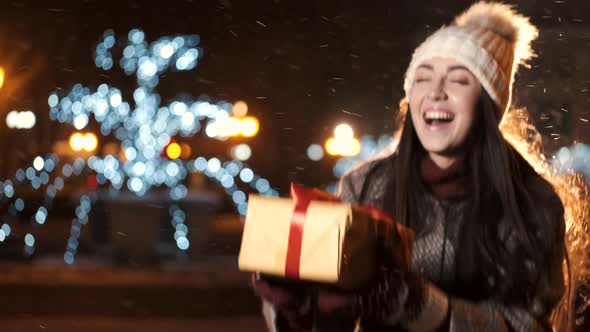 Beautiful Young Girl Unpacks Her Box with a Christmas Gift