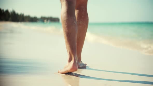 Guy Relaxing On Tropical Beach Resort In Honeymoon Vacation Holiday. Man Legs Walking On Beach.