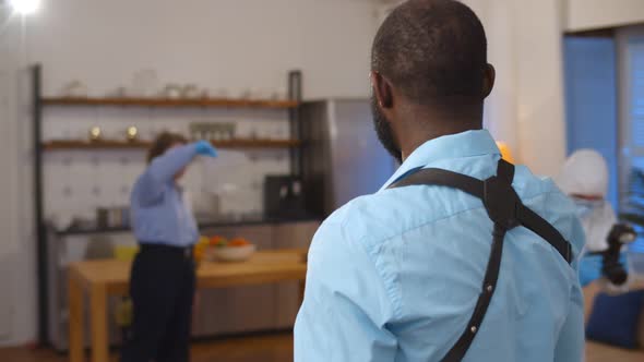 Back View of African Detective Giving Orders To Forensic Team Working at Crime Scene