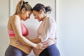 Happy pregnant women toching each others bellies. Multiathnic couple sorority - PhotoDune Item for Sale