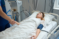 Pretty lady lies in intensive care, looking at nurse - PhotoDune Item for Sale