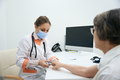 Doctor attaches pulse oximeter to the finger of elderly patient - PhotoDune Item for Sale