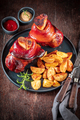 Cripsy grilled ham hock on a plate with baked potatoes. - PhotoDune Item for Sale