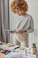 Indoor shot of curly woman interior designer concentrated in tablet screen finds best design for - PhotoDune Item for Sale