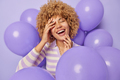 Photo of cheerful curly haired adult woman keeps eyes closed laughs joyfully glad to celebrate - PhotoDune Item for Sale