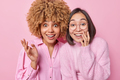 Positive multiethnic female friends smile broadly react to something awesome stand closely to each - PhotoDune Item for Sale