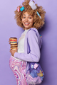 Cheerful pregnant woman holds tasty doughnuts carries net bag with toys has big belly smiles broadly - PhotoDune Item for Sale
