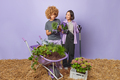 Horizontal shot of busy female gardeners discuss how to care about house plants hold pots of flowers - PhotoDune Item for Sale