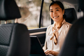 Happy Asian businesswoman commuting to work and working on laptop while sitting on back seat of car. - PhotoDune Item for Sale