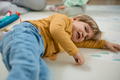 Sad little boy crying while lying down on floor. - PhotoDune Item for Sale
