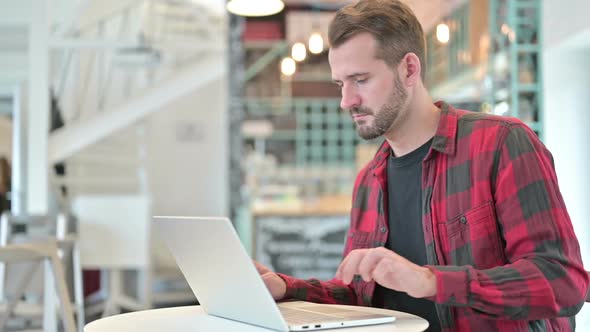 Young Man with Laptop Standing and Going Away