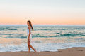 Adorable teen girl in white on the seashore during her beach summer vacation with amazing sky on - PhotoDune Item for Sale