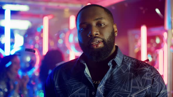 Serious African Man Staring at Lens in Club. Afro Guy Spending Time at Party