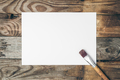 Blank sheet of paper and brush for drawing on a wooden background, flat lay. - PhotoDune Item for Sale