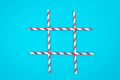 A tic-tac-toe board game made of paper drinking straws on a blue background. - PhotoDune Item for Sale