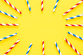 Multicolored party drinking straws arranged into a circle on yellow background. - PhotoDune Item for Sale