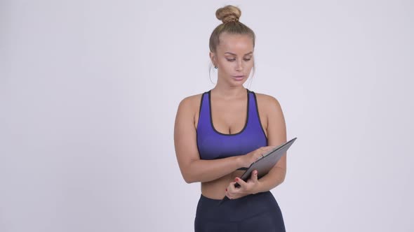 Young Blonde Woman As Gym Instructor Talking and Holding Clipboard