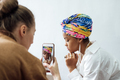 Fashion designer taking photo of young African woman model with colorful shawl on her head and - PhotoDune Item for Sale