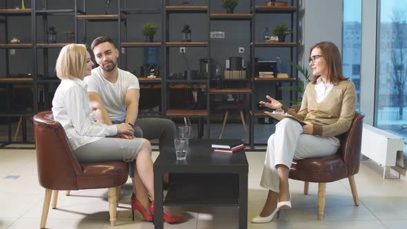 Caucasian Married Couple Sit Together in Modern Office of Psychologist