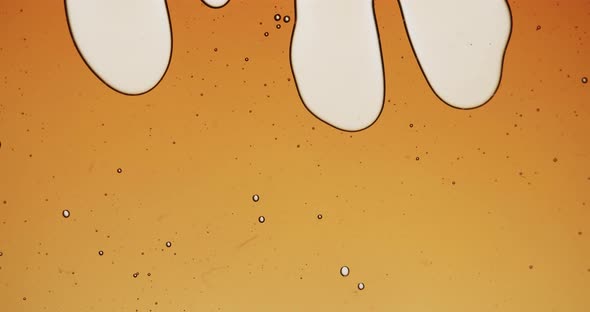 Macro shot of sirup getting squished. Transparent liquiding very slowly and forming strange forms an