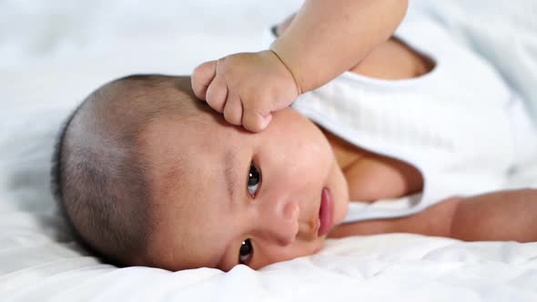 slow-motion of baby lying on a bed at home