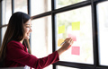 Young smiley attractive, businesswoman using sticky notes in glass wall to writing strategy business - PhotoDune Item for Sale
