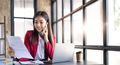 Portrait of a cheerful young business Asian woman using smartphone application in workplace office - PhotoDune Item for Sale