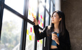 Young creative woman professional using sticky notes in glass wall to writing strategy business plan - PhotoDune Item for Sale