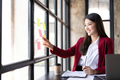 Young smiley attractive, businesswoman using sticky notes in glass wall to writing strategy business - PhotoDune Item for Sale