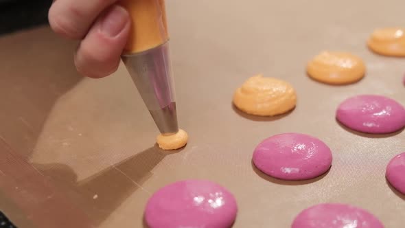 Chef Make of a Pink and Orange Macaroons Pour the Filling on the Baking Paper