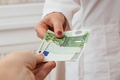 Female doctor getting some euros from her customer, payment. - PhotoDune Item for Sale