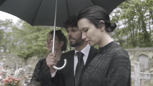 Family Mourning on graveyard at funeral