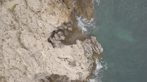 Rocks and Waves. Aerial Vertical Shot. Flat Color