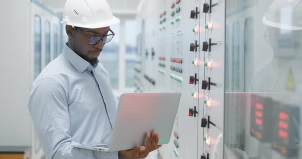 Man Using a Laptop While Working in a Server Room